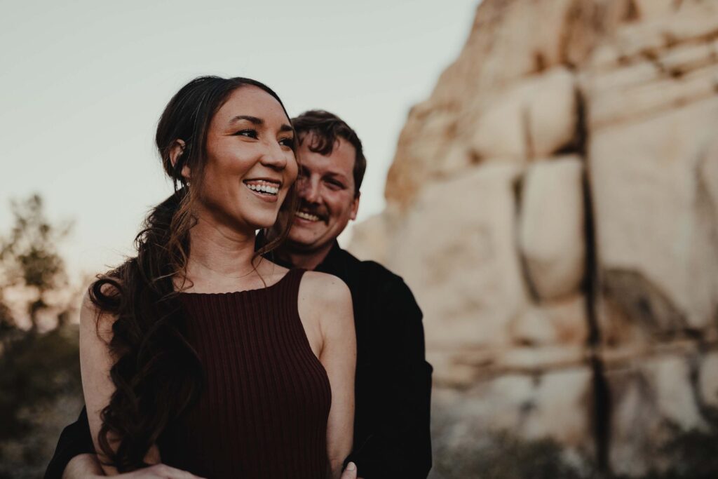 Cute couple smiles during an engagement photo shoot in Joshua Tree National Park