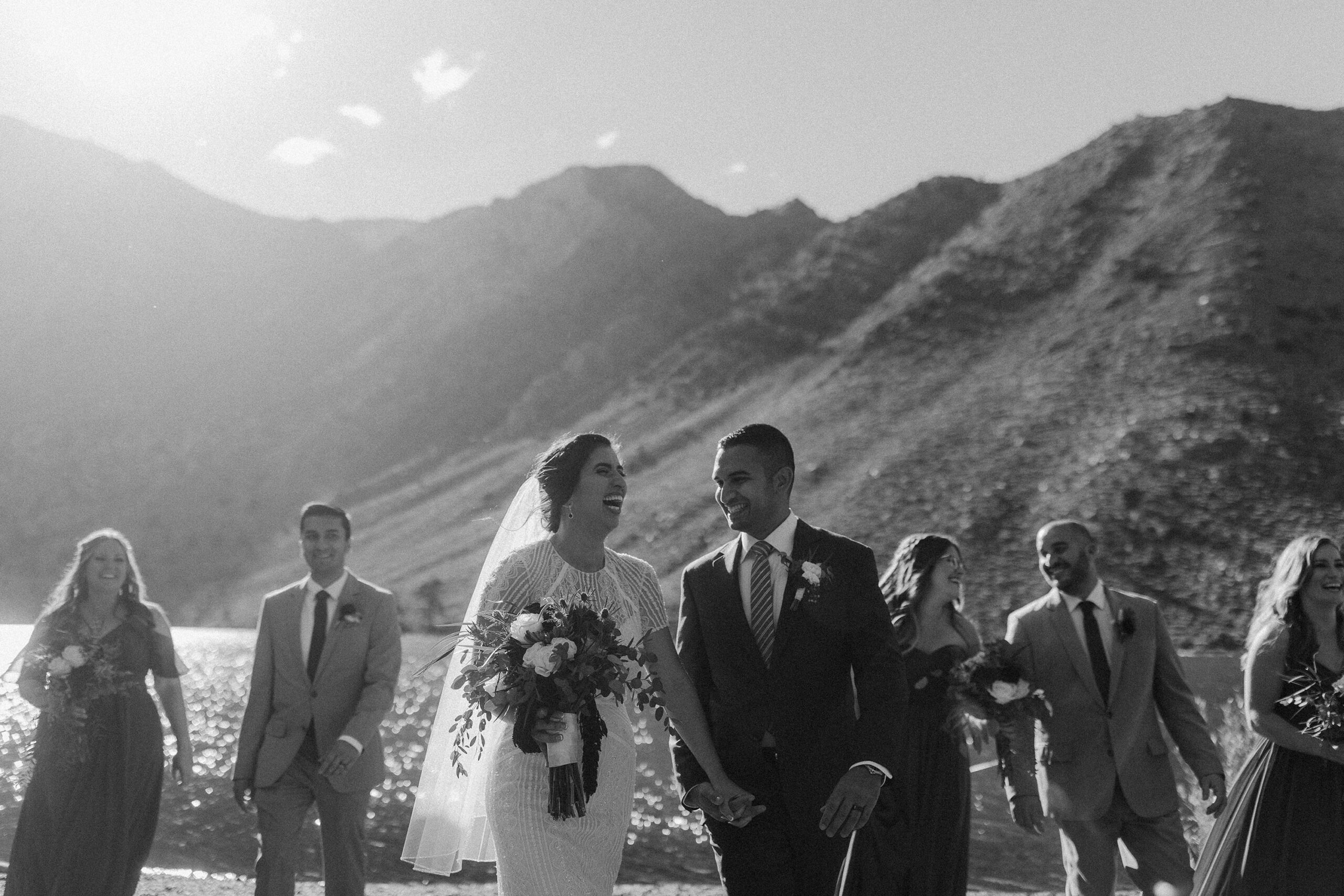 A candid image of a Bride and Groom with their bridal party laughing by Convict Lake